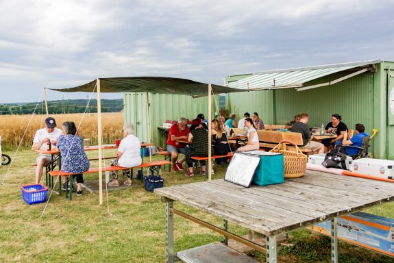Gemeinsame Vereinsabende auf dem Platz Vereinsmitglieder sitzen zusammen und Essen